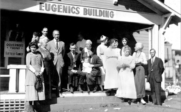 Group of people standing in front of building with "Eugenics Building" on facade